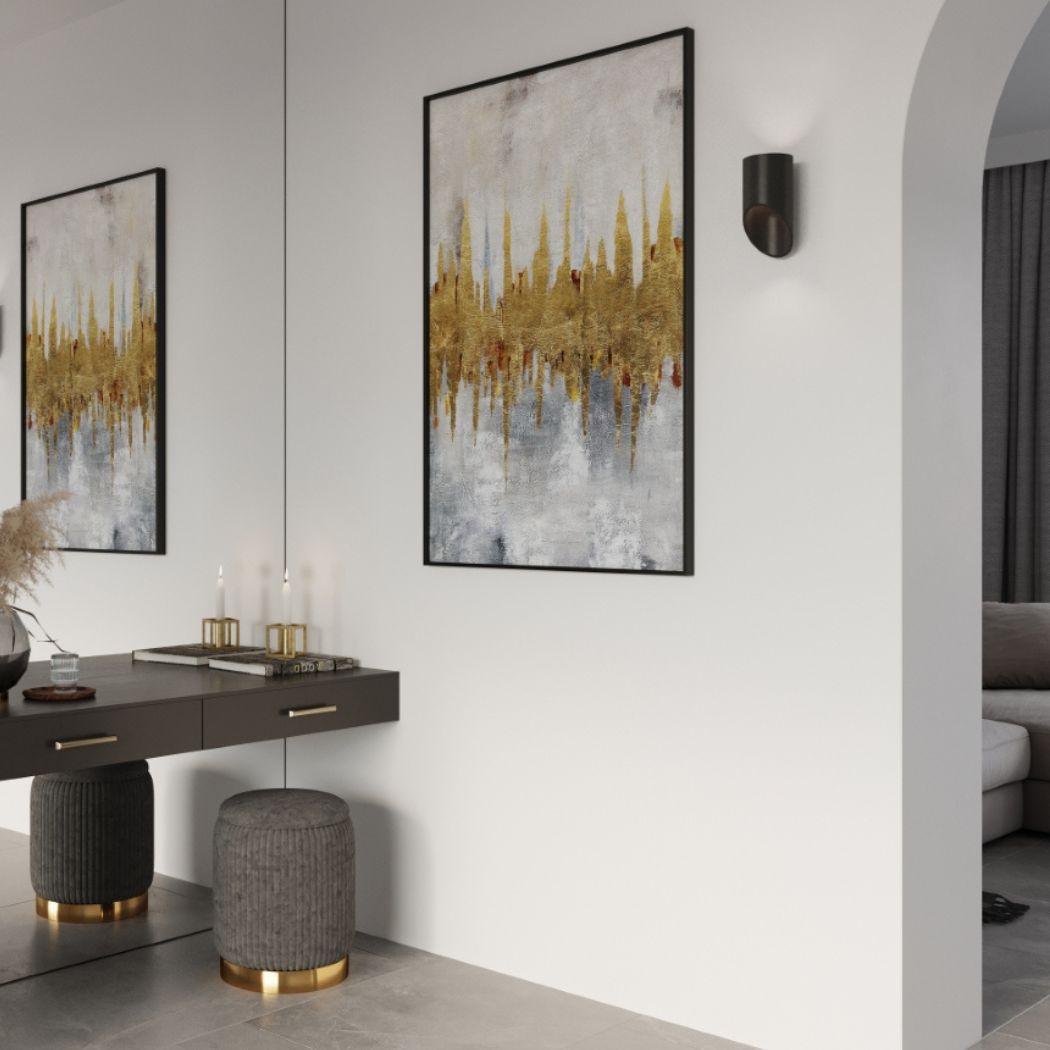 Small round dark wall light beside a framed abstract painting near an archway