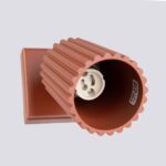 Close-up inside a terracotta ribbed spotlight showing the bulb socket