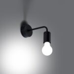 Wall light glowing at night, warm bulb light against a dark gray wall