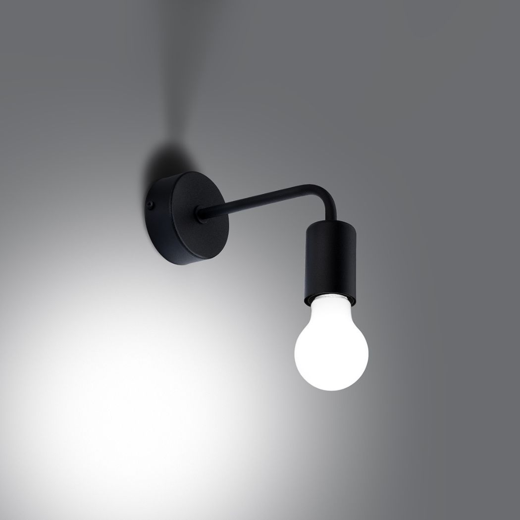 Wall light glowing at night, warm bulb light against a dark gray wall