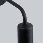 Extreme close-up of the curved black arm and bulb holder of the wall light