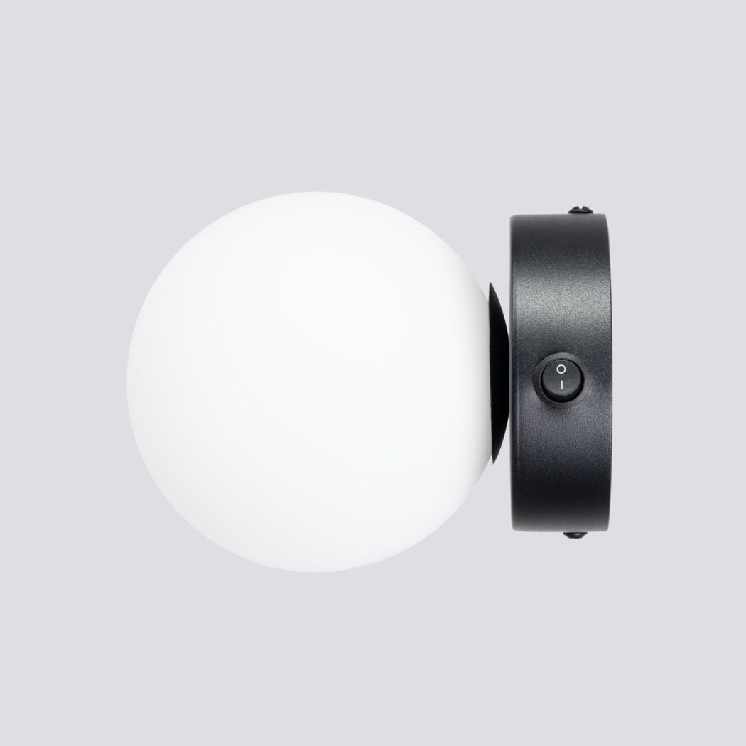 Side view of the black round glass ball wall light with its toggle switch