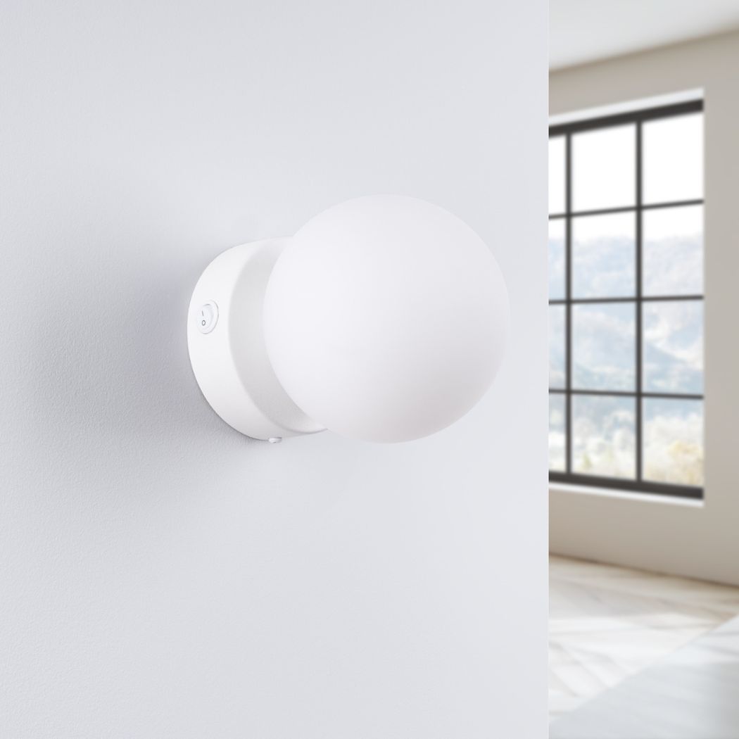 White round glass ball wall light shown unlit beside a large black-framed window