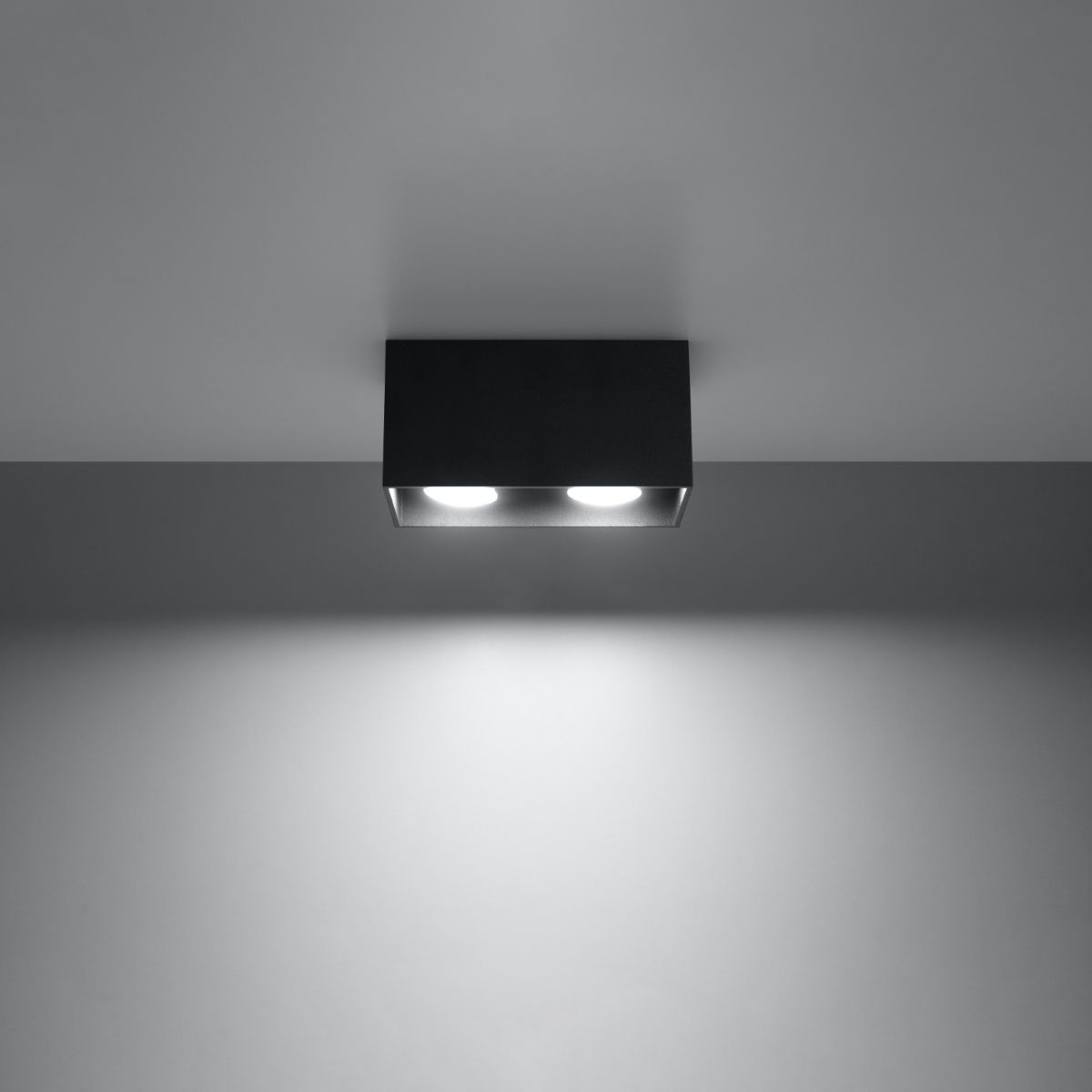 Black rectangular surface ceiling light casting two round beams of light