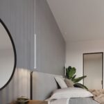 Slim white pendant hanging beside a headboard with a round mirror and plant