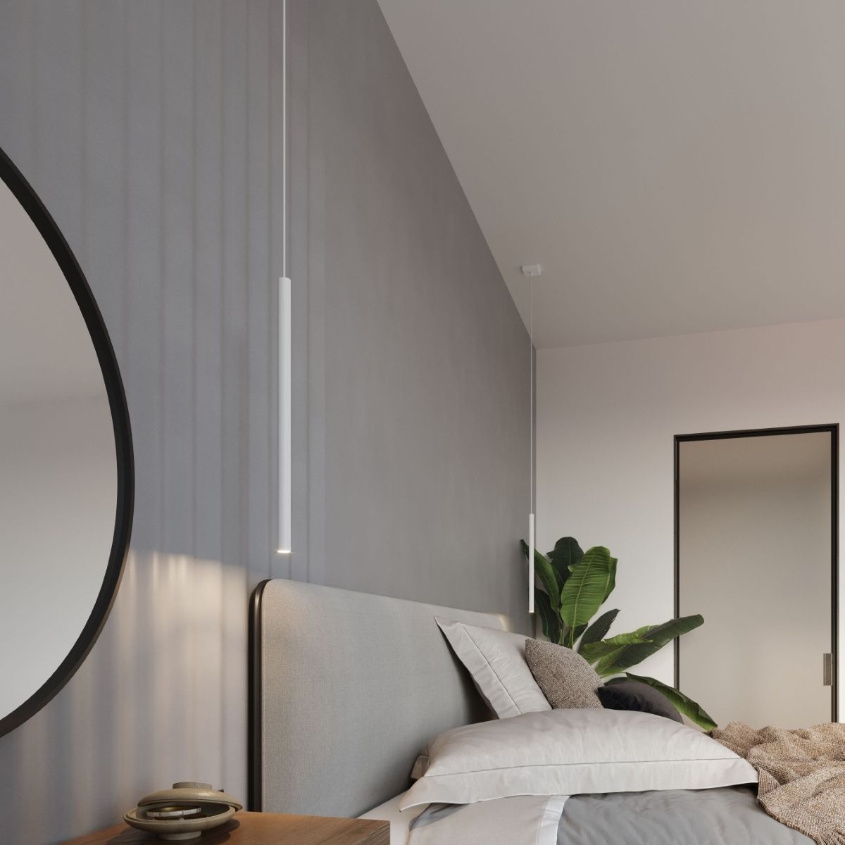 Slim white pendant hanging beside a headboard with a round mirror and plant