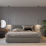 Two black slim pendants hanging beside a bed with a round mirror and grey striped wall