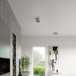 Small gray two spot ceiling light near a dark TV cabinet