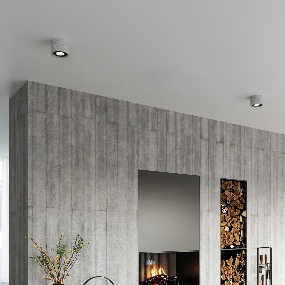 Two concrete cylinder ceiling spotlights above a stone wall with fireplace