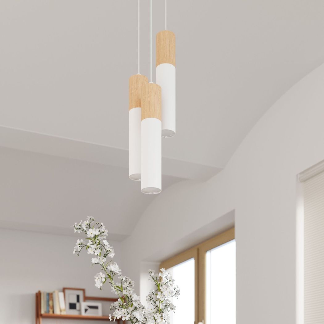 Three white and wood pendant lights hanging near a window and flowers
