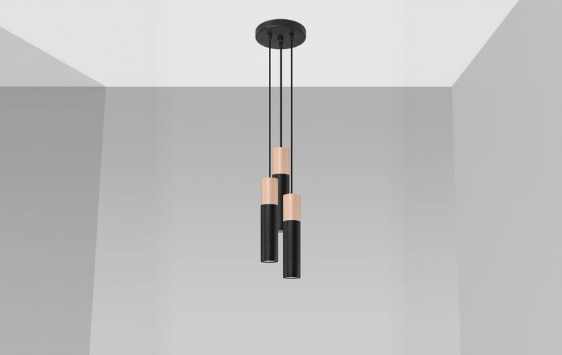 Three black and wood cylinder pendant lights against a light staircase wall