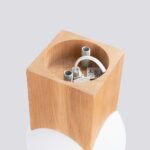 Underside view of the wooden cube showing the exposed wiring and bulb socket