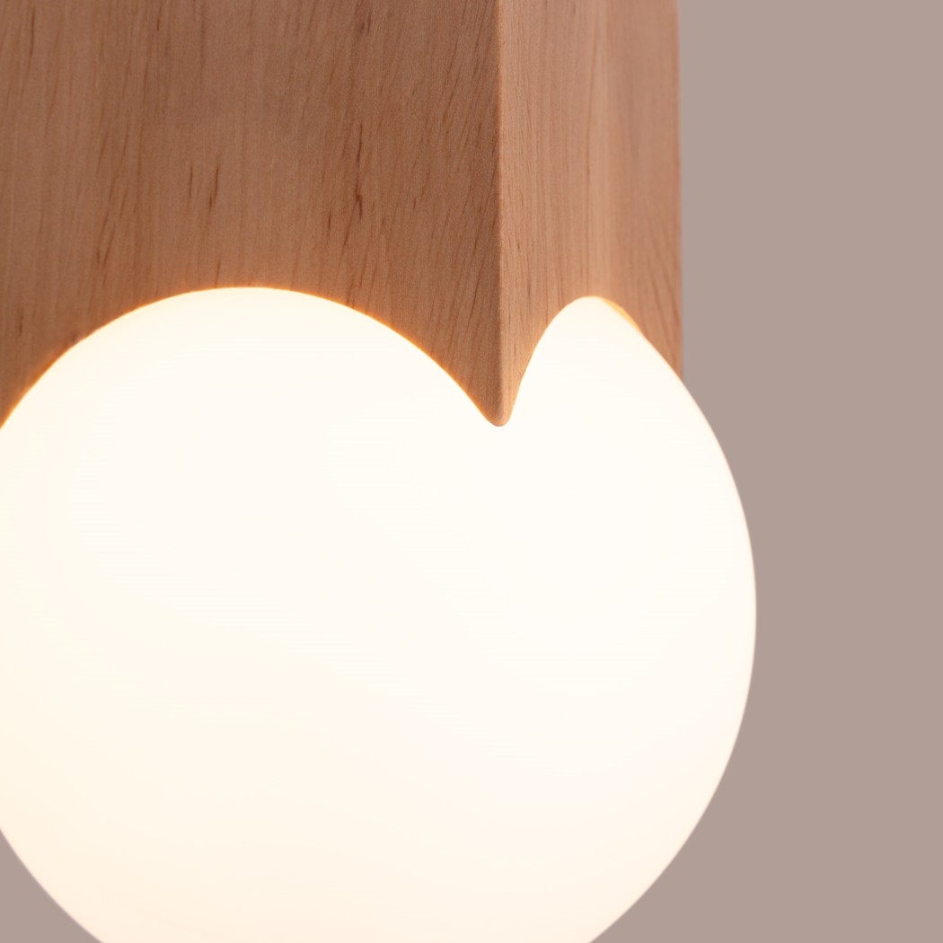 Close-up of the wooden block edge and the glowing opal glass globe