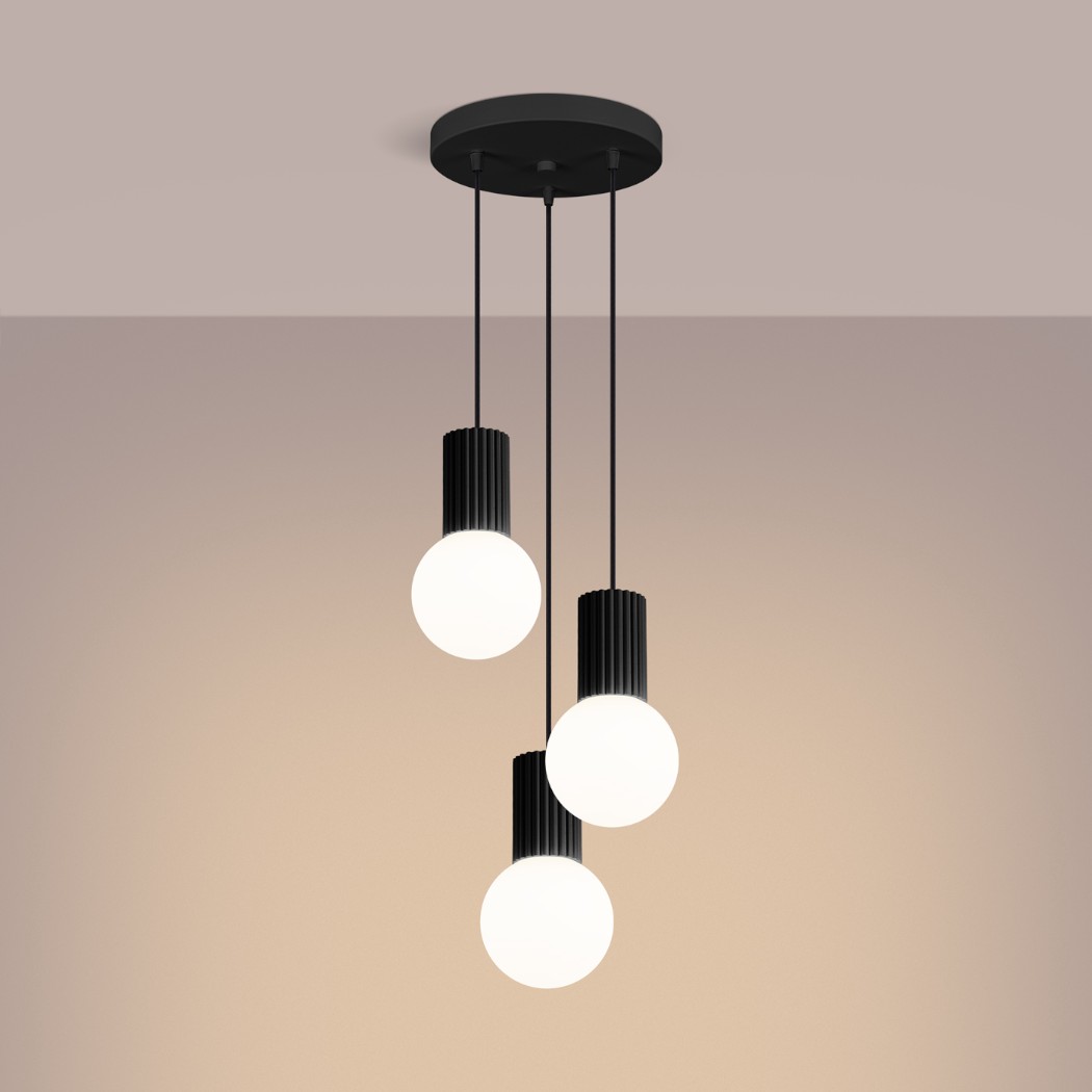Three black ribbed pendants with round glass globes hanging at staggered heights