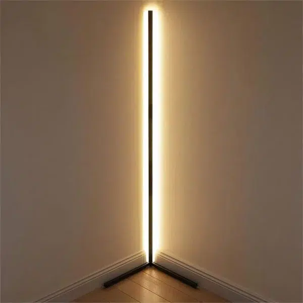 Smart Connected LED Corner Floor Lamp Black corner LED floor strip glowing warm light along a wall corner