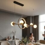 Linear pendant light with six gold rings and opal glass globes above a dining table