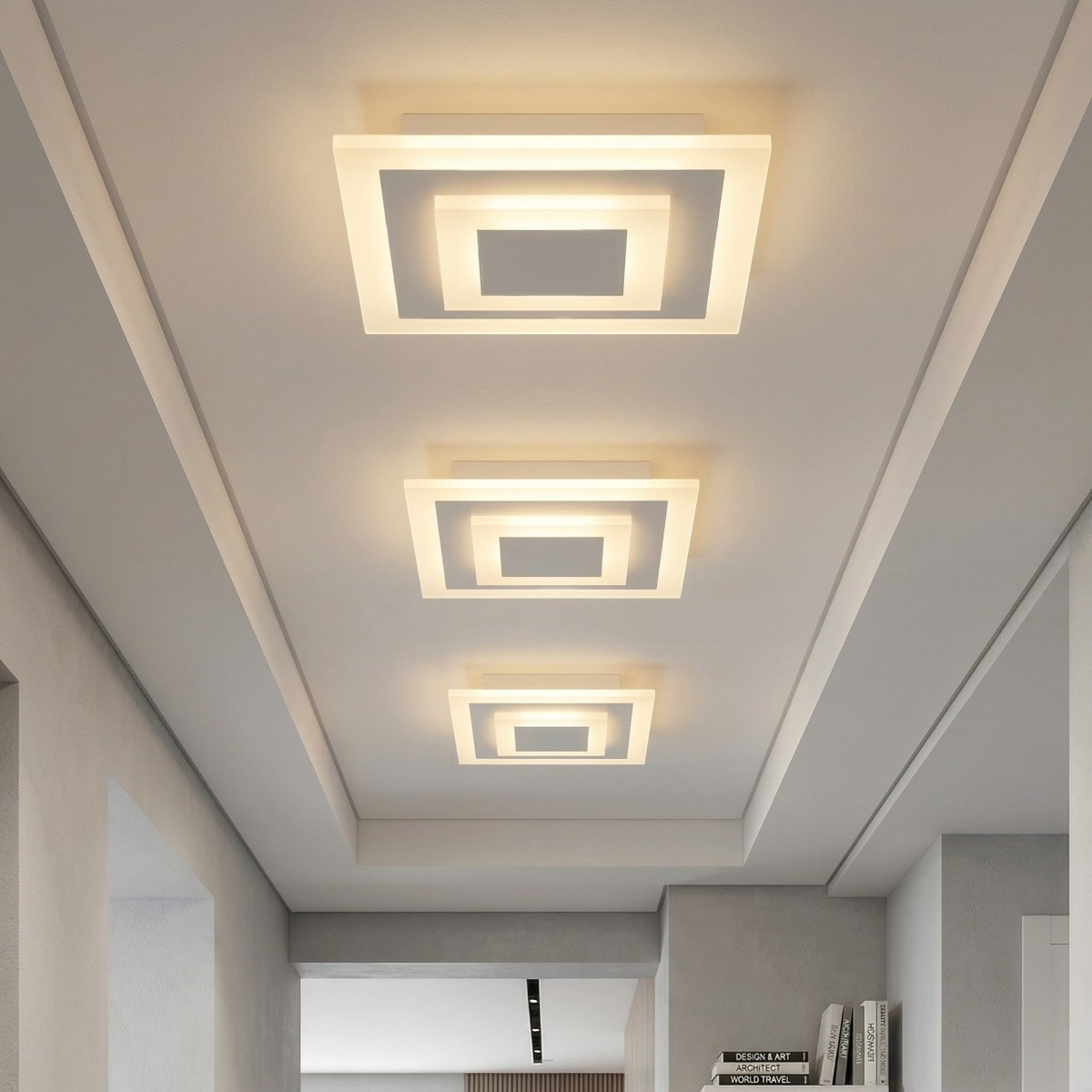 Three square LED ceiling lights with layered frames along a hallway