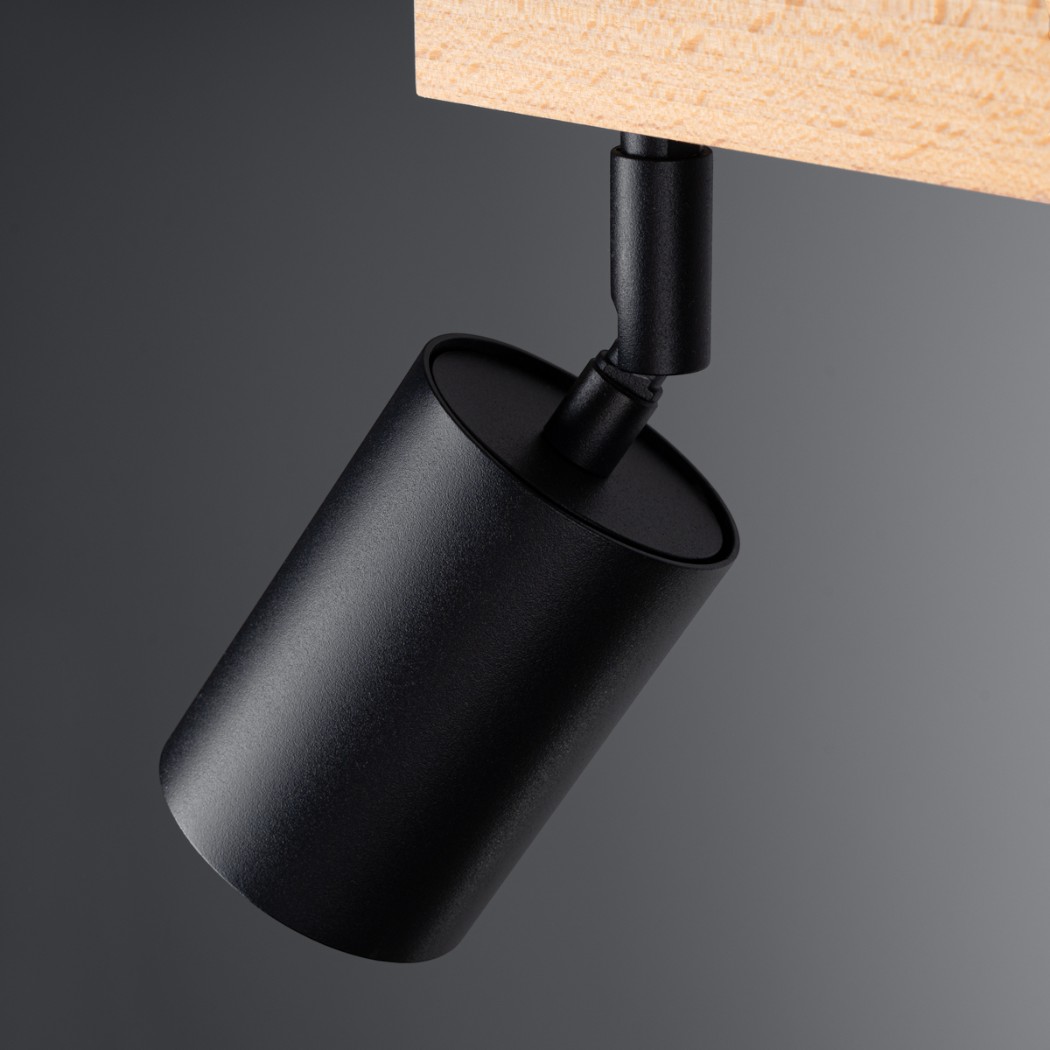 Close-up of one black cylindrical spotlight head mounted on the wooden bar