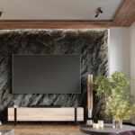 Adjustable ceiling spotlights above a marble accent wall with a TV