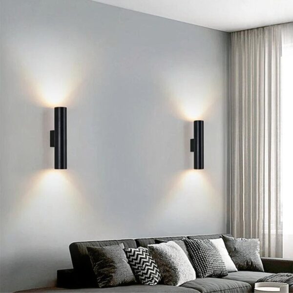 Black cylindrical wall lights in pairs casting light up and down