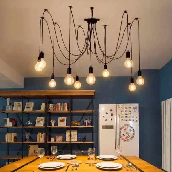 Black spider ceiling light with looping arms and bare bulbs over a dining table
