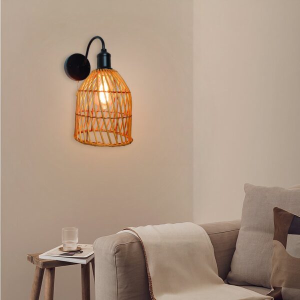 Orange woven rattan basket wall light on a black curved arm