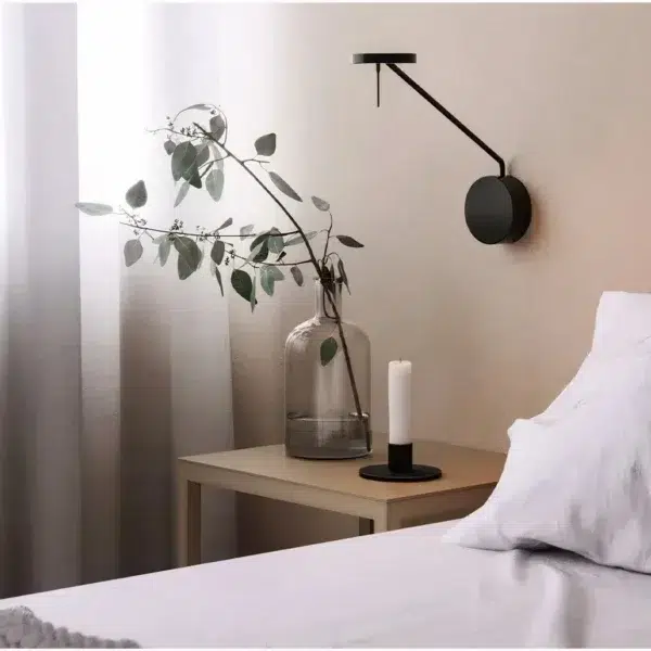 Nordic LED Reading Wall Light with Swing Arm Black swing-arm wall light with a slim angled arm beside a bed