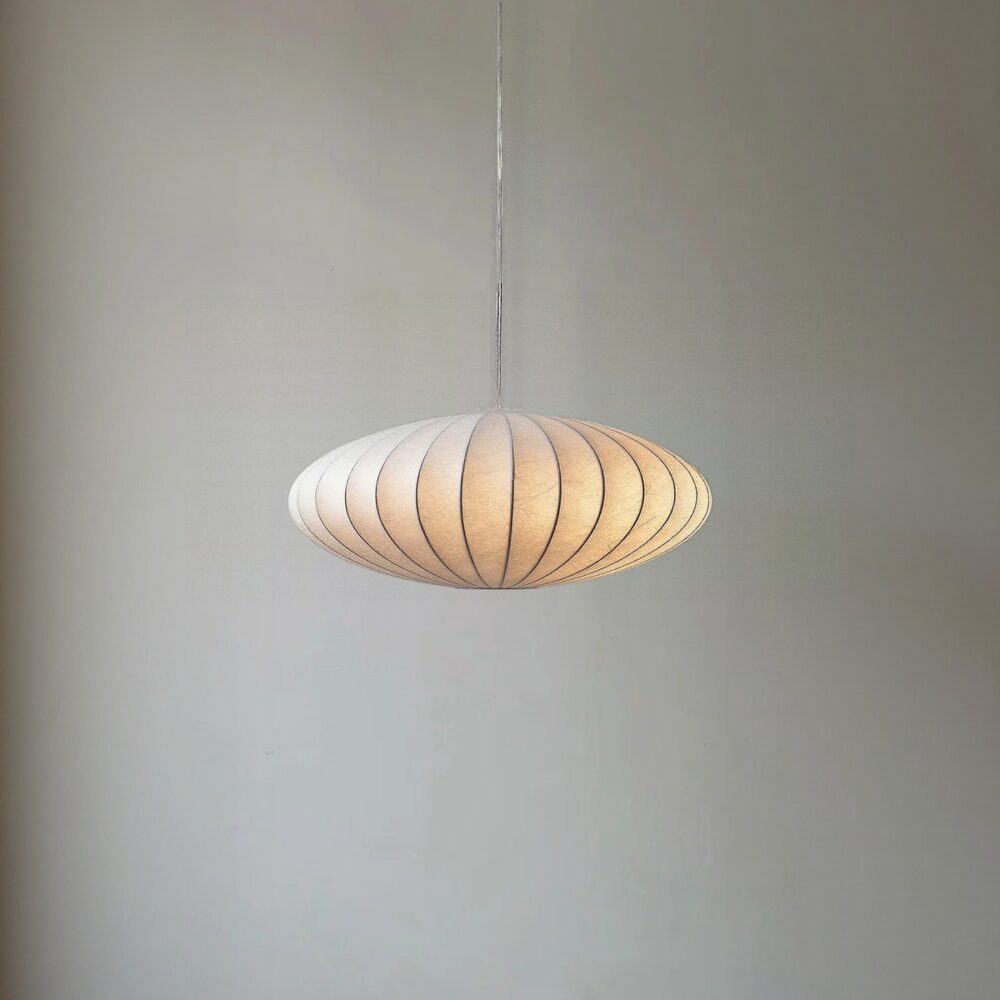 Oval pendant light with a finely ribbed white natural fibre shade