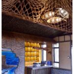 Woven fish-shaped pendant lights hanging beneath a knotted rope canopy