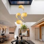Four wave-shaped wooden pendants clustered beneath a skylight