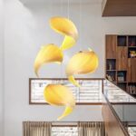 Sculptural pleated yellow pendant lights swirling above a staircase landing