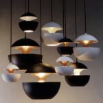 Cluster of black and white hemisphere pendants glowing at different heights