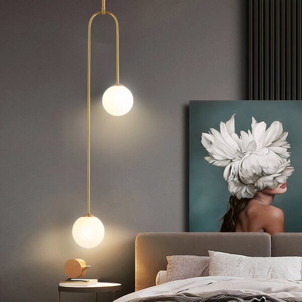 Gold arched pendant light with two round glass globes at different heights