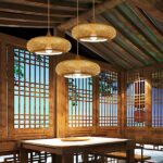 Row of three bamboo drum pendants above a table on a wooden veranda