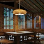 Woven rattan dome pendant light hanging above a wooden table in a lattice window dining room