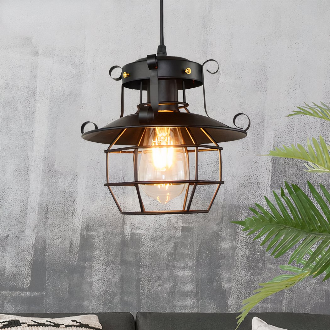 Black lantern style industrial pendant light with scroll details and visible bulb