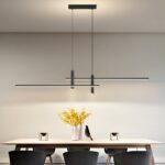 Black linear LED pendant with two spotlight heads above a dining table