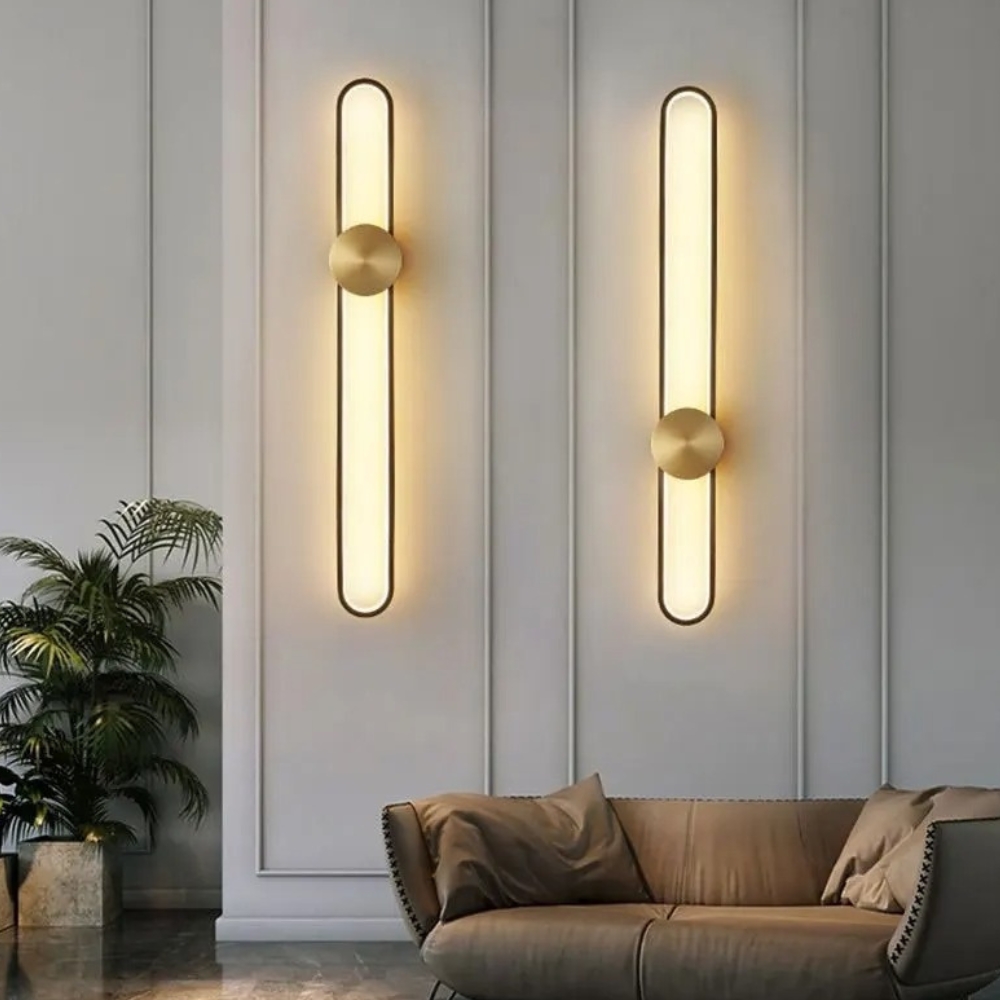 IMG_01_05_applique_murale_led_design_minimaliste_1.jpg Two slim rounded LED wall lights glowing warm above a sofa
