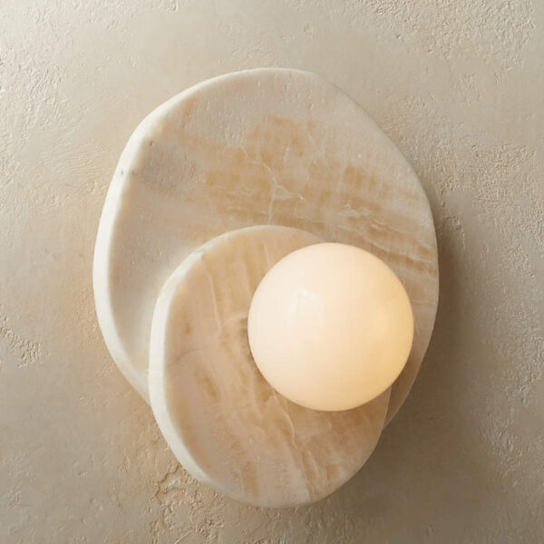 Round natural stone wall light with a spherical glass globe
