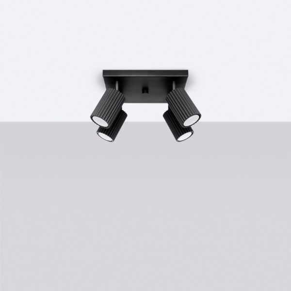 Black ceiling bar with four fluted cylindrical spotlights angled outward