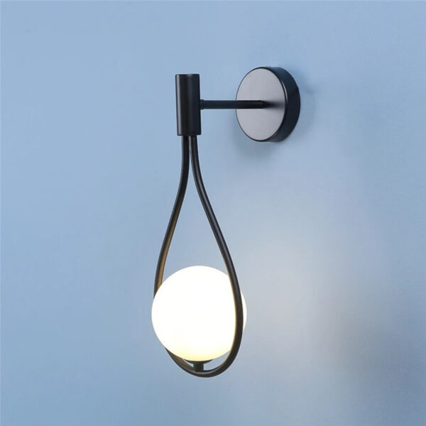 Design wall lamp with suspended water-drop globe Black wall light with a teardrop shaped loop holding an opal glass ball