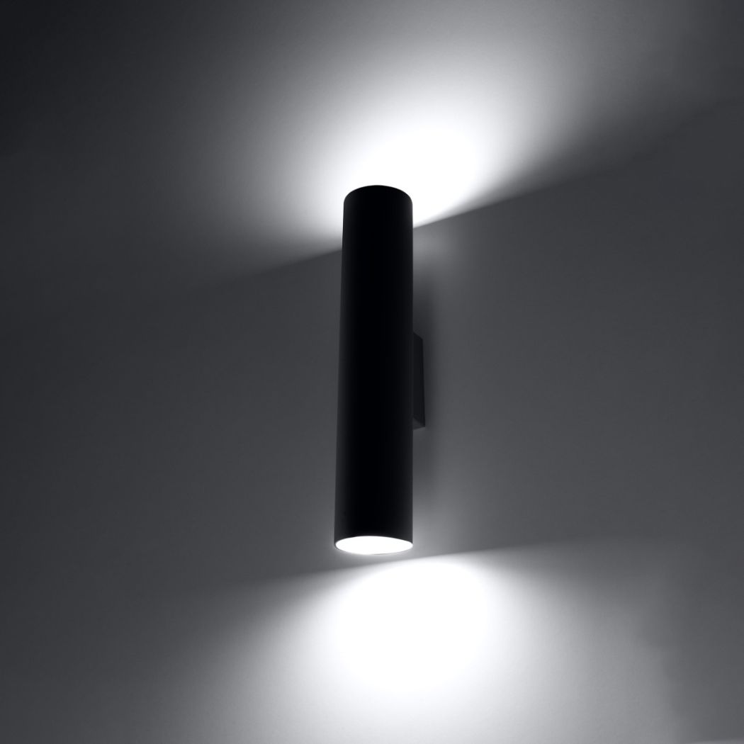 Black cylindrical wall light lit with light cast upward and downward