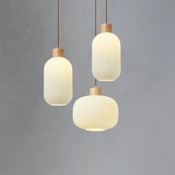 Three ribbed opal glass pendant lights of different shapes with wood caps