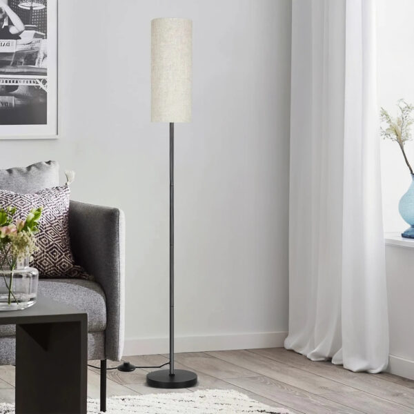 Slim black floor lamp with a round cream fabric cylinder shade