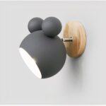Grey wall light shaped like a bear head on a round wood disc
